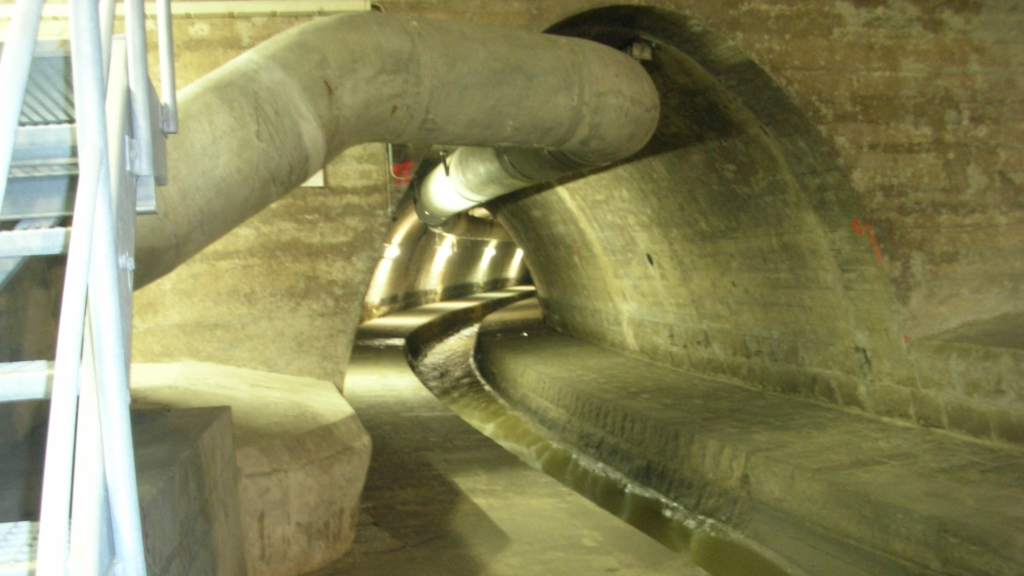 Un tuyau au milieu d'un tunnel avec un canal d'eau.